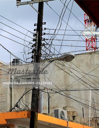 messy electric cables wooden pole busy skyscape sky in Mexico