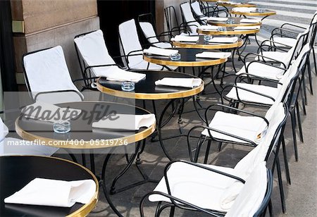 Street view of a Cafe terrace with empty tables and chairs