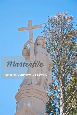 Portugal sculpture of a woman with a cross against the sky