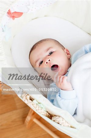 Portrait of a lively baby lying in his cradle at home