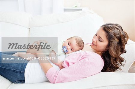 Young mother taking care of her adorable baby at home