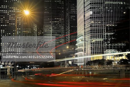 Business buildings with cars motion blurred light in night.