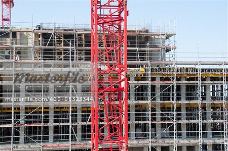 Construction site with red crane and building