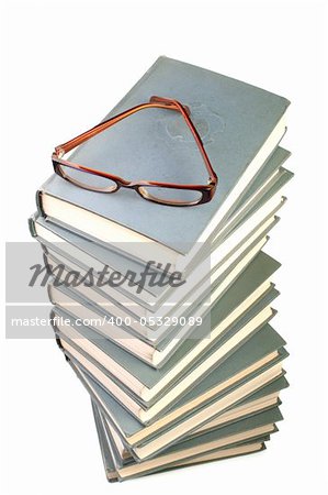 Stack of books and eyeglasses isolated on the white