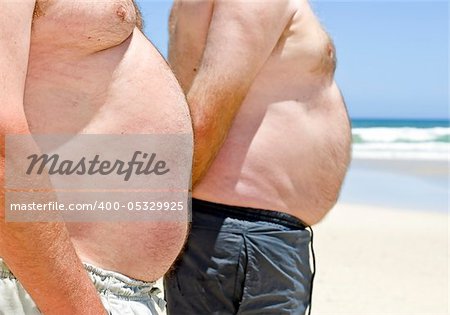 Close up of two obese fat men of the beach