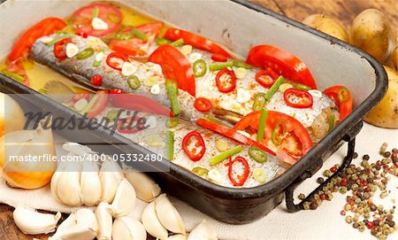 Tasty roasted fish with vegetables in pan