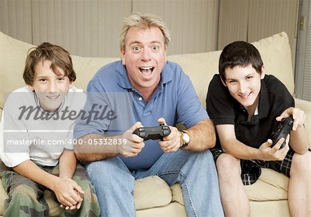 Uncle or father playing video games with two boys.