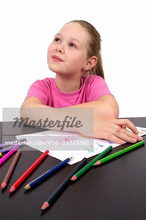 The girl draws a picture with color pencils
