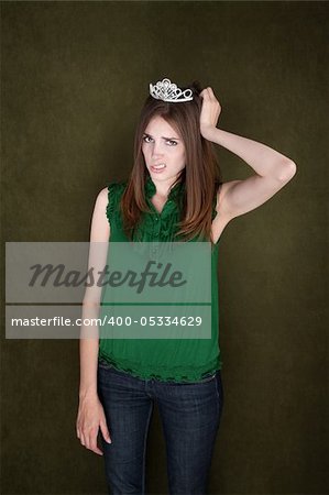 Unhappy woman with a tiara holds her head