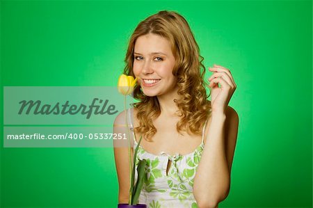 HappyClose up on a green background Happy young woman hugging a yellow tulip. Young Woman Hugging Flower