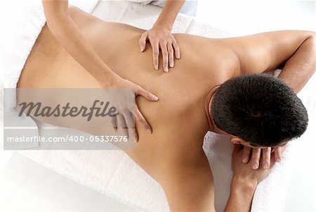 Unrecognizable man receiving massage relax treatment close-up from female hands