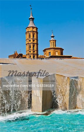 The Fountain on the Background of the Bell Tower of the Catholic Church in Zaragoza
