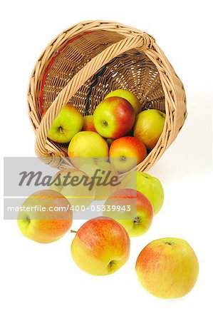 Fresh apples spilling out of basket - isolated on white background. Clipping path included.