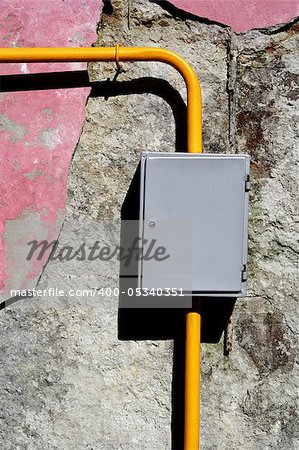 Yellow gas pipe grey gauge box close-up foto