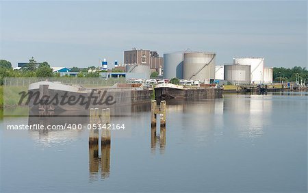 two freighters in the harbor of Zwolle, netherlands with some oil tanks in the background