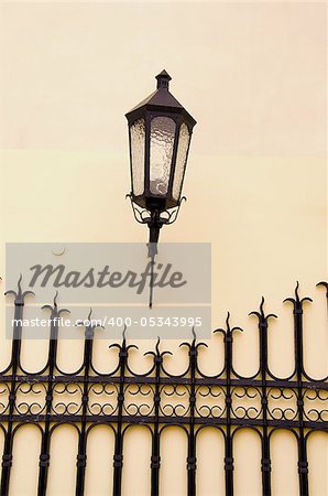 old town street fragment with lamp and metal fence