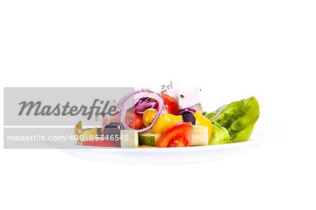 Greek salad on a plate. On a white background.