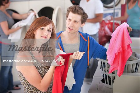 Upset man and woman with stained clothes in laundromat