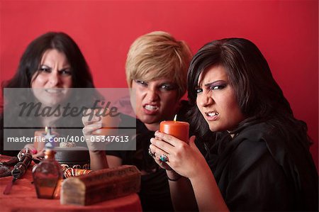 Witch coven with candles over red background