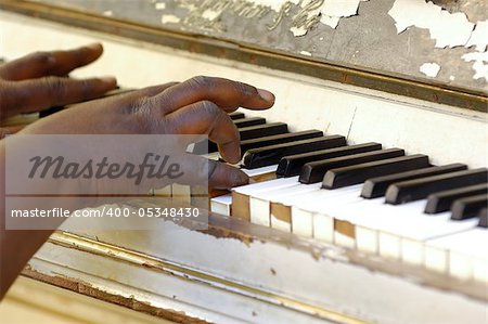 Musician is playing on a very old piano