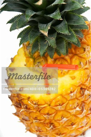 ripe pineapple cut on top with red straw