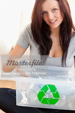 Woman recycling plastic bottles in a living room