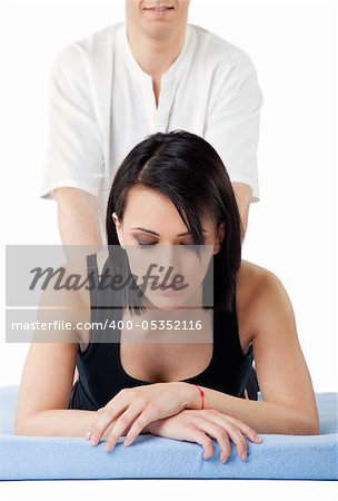 Young woman receiving lower back thai massage from a man, eyes closed