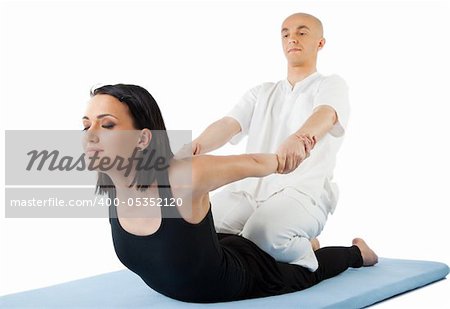 Young female receiving massage by therapist in traditional thai position