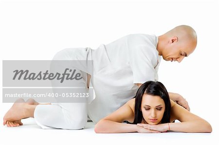 Beautiful woman lying and receiving traditional thai massage from therapist, eyes closed