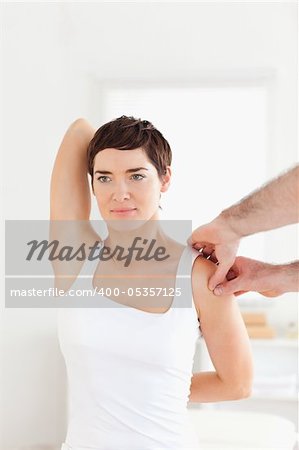 Brunette Patient doing some exercises under supervision in a room