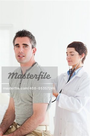 Doctor examining a patient with a stethoscope in a room