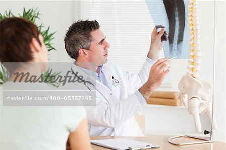 Male Doctor showing a female patient a x-ray in a room