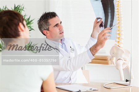 Male Doctor showing a patient a x-ray in a room
