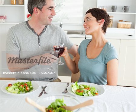 Close up of a cute couple toasting with redwine in a dining room