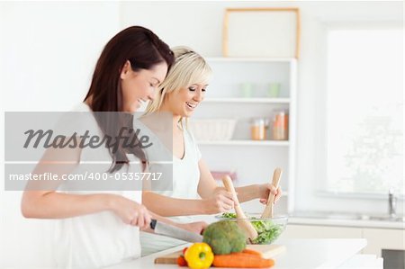 Joyful young Women preparing dinner in a kitchen
