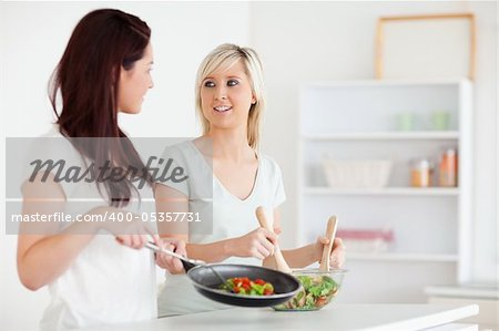 Smiling Women cooking dinner in a kitchen