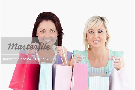 Cheerful young women with shopping bags in a studio