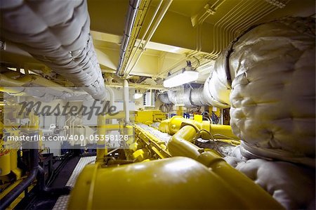 The engine room of a tugboat with valves, vents, exhaust, pipes and plumbing