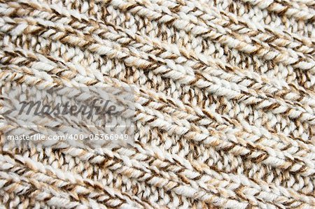 Knitted brown and white wool fabric, background.