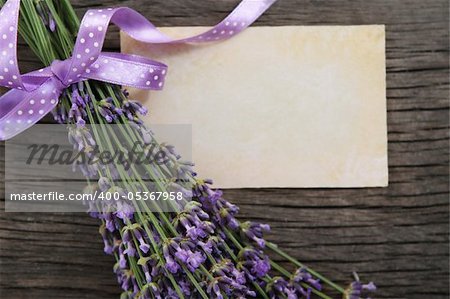 Fresh lavender decorated with ribbon over wooden background