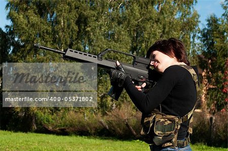 beautiful girl with a gun to airsoft outdoors