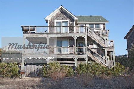 A beach house on the Outer Banks at Nags Head, North Carolina, against a bright blue sky