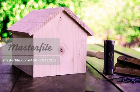 Small wooden house with hammer nails and ruler