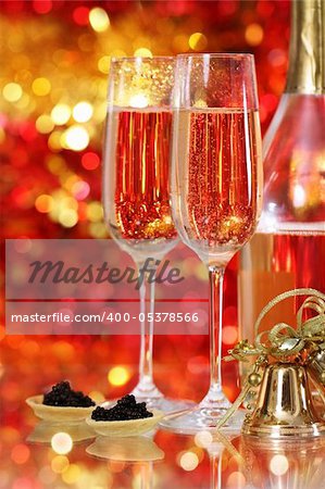 Champagne in two glasses with black caviar at the christmas background