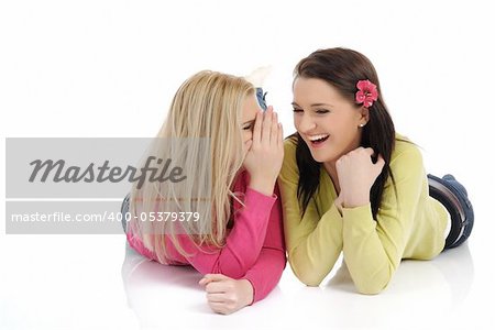 Two young pretty girls gossiping and enjoying conversation. isolated on white background