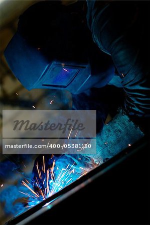 Close-up photo of a welder at work with sparks flying around