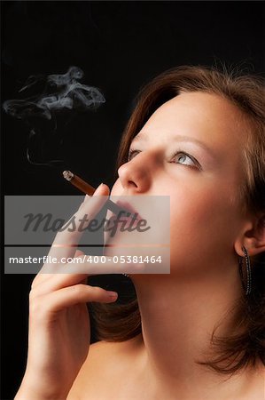 beautiful woman smokes a cigarette in the dark