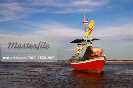 red fisherman boat lying on the tropical beach