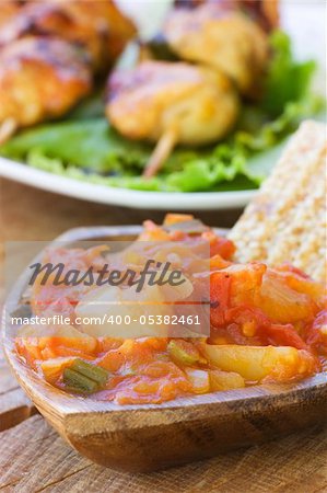 Tomato and paprika salsa in wooden bowl.