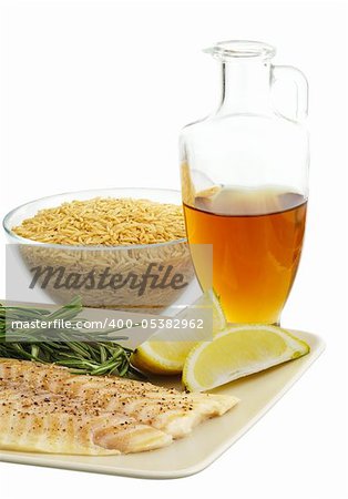 Mediterranean diet dinner ingredients including fresh fish, brown rice, herbs, lemon and olive oil